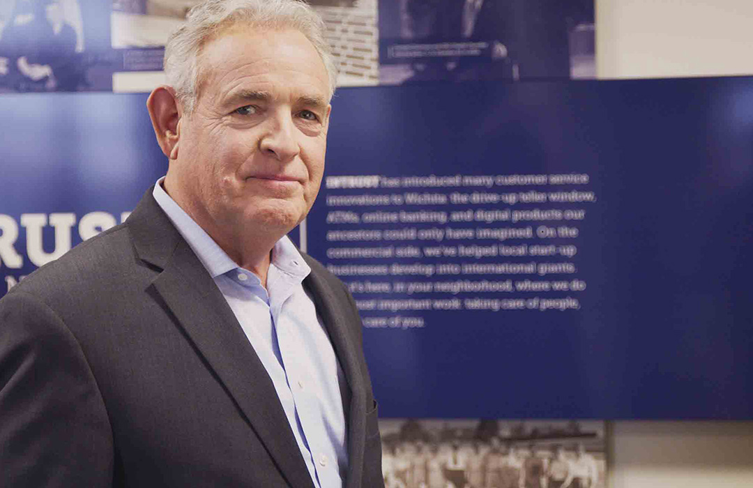 A man looking in to the camera standing in a banking center